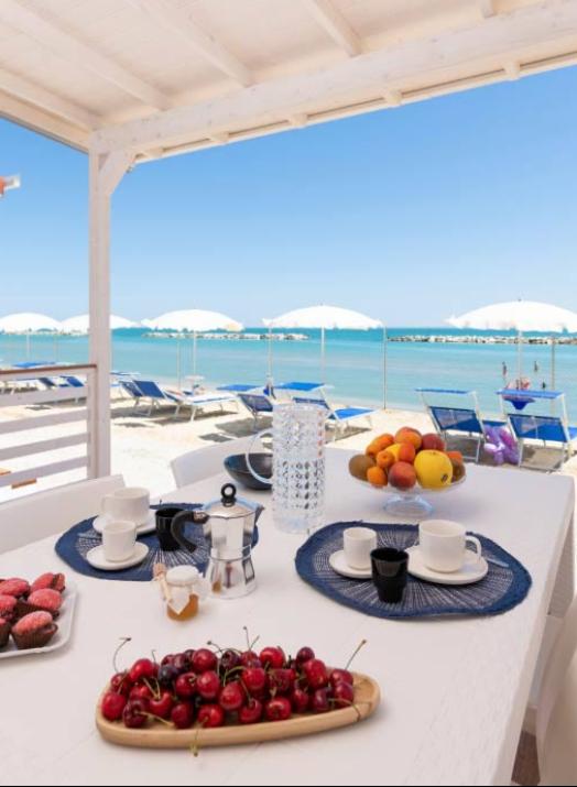 Colazione in veranda con vista mare, frutta fresca e dolci.