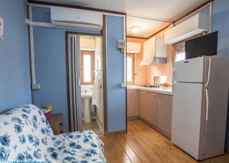 Accogliente bungalow con cucina, bagno, divano e aria condizionata.