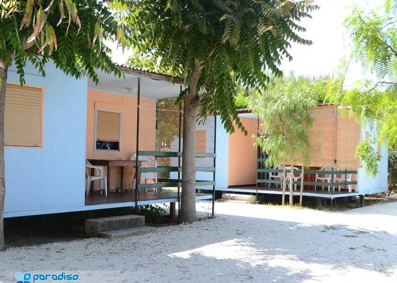 Bungalow immersi nel verde del Camping Paradiso, perfetti per una vacanza rilassante.