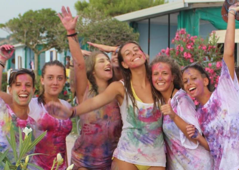 Gruppo di amici felici con magliette colorate durante una festa all'aperto.