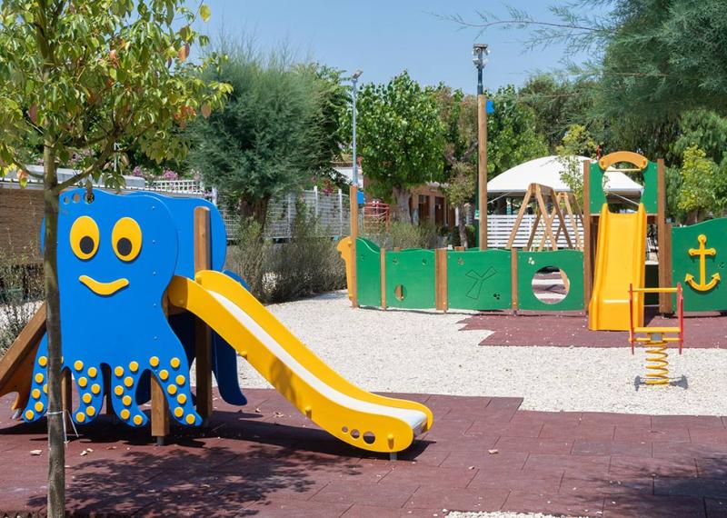 Parco giochi con scivoli colorati e strutture divertenti per bambini.